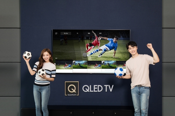 삼성전자 모델들이 2018년형 QLED TV의 AI기반 축구 큐레이션 서비스를 통해 축구 경기를 시청하고 있다 (사진=삼성전자)