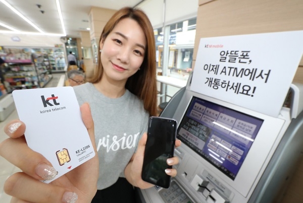 KT엠모바일 직원이 ATM을 통해 알뜰폰을 즉시 개통하는 모습을 시연해 보이고 있다.
