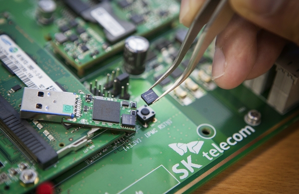 SK텔레콤 직원이 5x5mm 크기의 양자난수생성 칩을 들고 있다. (사진=SK텔레콤)
