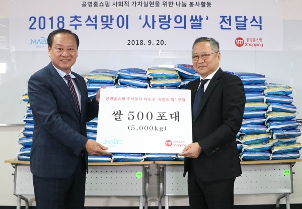 최창희 공영홈쇼핑 대표(오른쪽)가 유동균 마포구청장에게 쌀 500포대(5,000kg)를 전달하고 기념 촬영을 하고 있다.(사진=공영홈쇼핑)