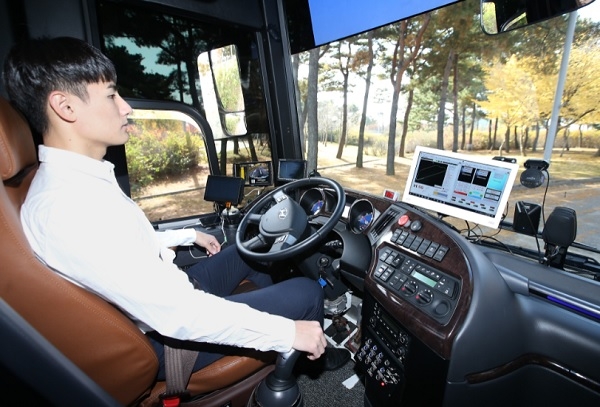 KT 자율주행 버스를 탑승한 KT 직원이 양손을 놓고 차량으로 전달되는 신호를 확인하고 있다.(사진=KT)