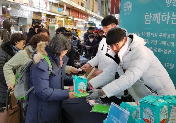 KT가 15일 서울 마포구 망원시장에서 소상공인 지원 온마켓 행사를 진행하며, 시장 방문 고객들에게 장바구니와 온쫄면, 온음료 등을 나눠주고 있다 (사진=KT)