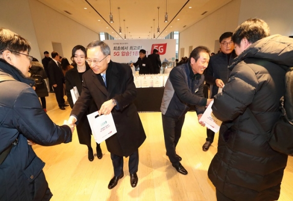 KT 황창규(왼쪽) 회장이 KT노동조합 김해관 위원장과 함께 새해 첫 출근하는 KT 직원들에게 응원선물을 증저하고 있다.
