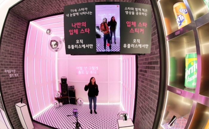 고객들이 LG유플러스 U+AR을 통해 TV속 스타와 함께 춤을 추며 영상을 촬영하고 있다.