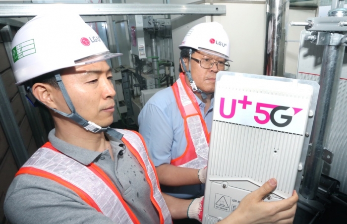 LG유플러스 직원들이 5G 기지국 장비와 정류기를 설치하고 있다.