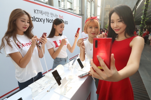 19일 노보텔 앰배서더 서울 동대문에서 열린 갤럭시노트10 출시 기념 론칭 파티에서 모델들이 KT 전용 아우라 레드 색상의 갤럭시 노트10를 보고 있다 (사진=KT)