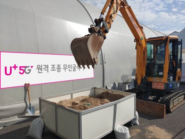 성남 서울공항 전시장 밖에 마련된 작업장에서 5G 무인 굴삭기가 시연을 펼치는 모습 (사진=LG유플러스)