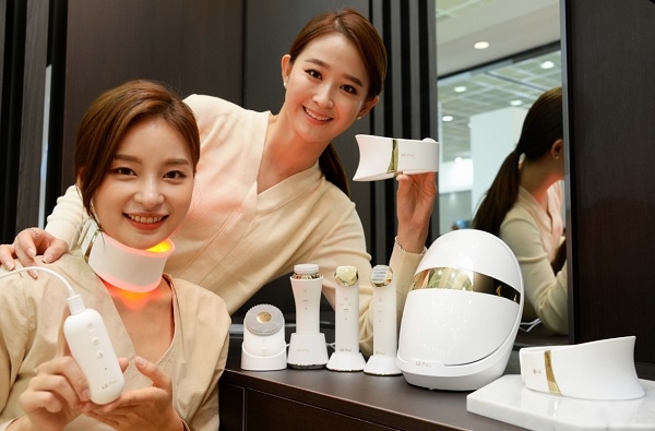 여성 모델들이 목 부위 피부 관리기기인 'LG 프라엘 더마 LED 넥케어' 제품을 소개하고 있다.(사진=LG전자)