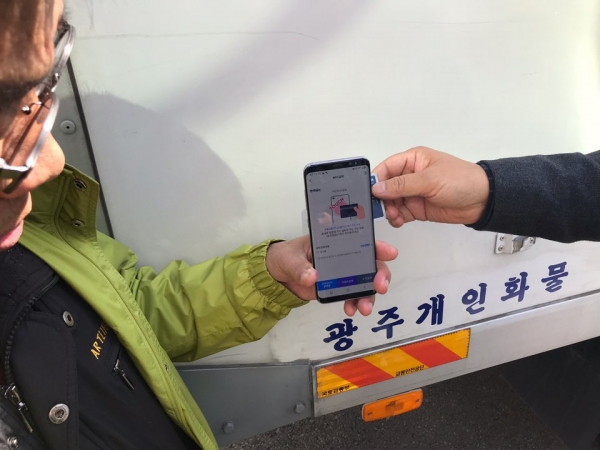 화물기사가 카드단말기 대신 스마트폰을 이용하여 고객에게 신용카드결제를 받고 있다