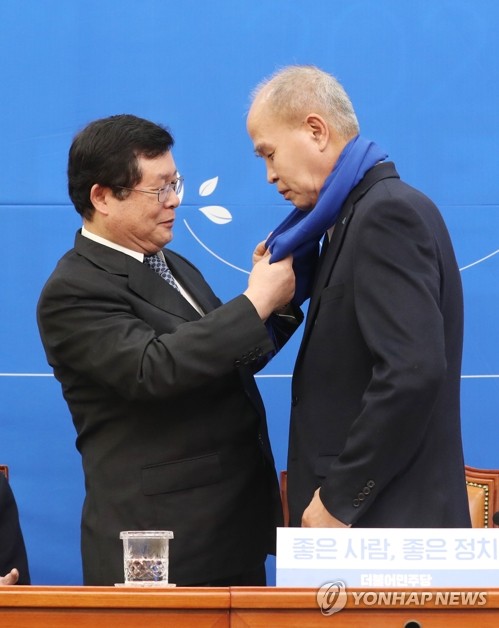 설훈 민주당 의원이 일곱번째 영입 인재인 이용우 카카오뱅크 대표에게 목도리를 둘러주고 있다. (사진=연합뉴스)