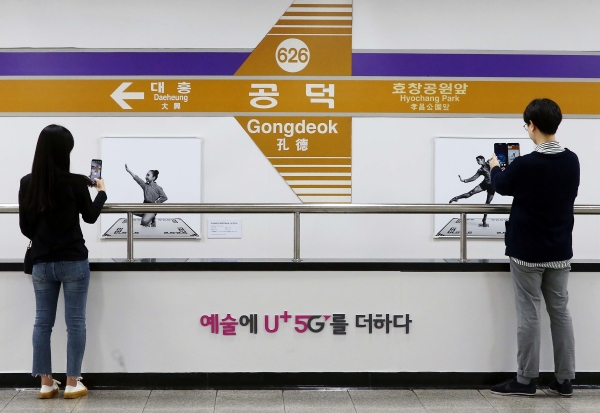 서울 지하철 6호선 공덕역에 마련된 5G 기반 문화예술 공간 ’U+5G 갤러리’에 방문한 고객이 ‘U+AR’ 앱으로 작품을 체험하고 감상하는 모습 (사진=LG유플러스)