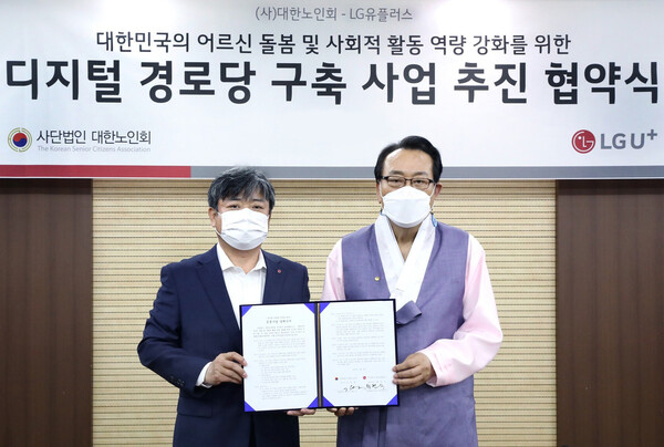 Choi Taek-jin, head of LG U+'s corporate division (left) and Kim Ho-il, chairman of the Korean Senior Citizens' Association, take a commemorative photo after signing a business agreement [Photo: LG U+]