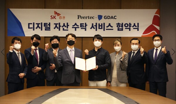 가상자산(암호화폐) 거래소 지닥 운영사 피어테크는 SK증권과 디지털 자산 커스터디(수탁) 서비스 협약을 맺었다고 24일 밝혔다. 김신 SK증권 사장(왼쪽 4번째)과 한승환 피어테크 대표(왼쪽 5번째) 등 관계자들이 협약 체결 후 기념 촬영을 하고 있다. [사진: 피어테크]