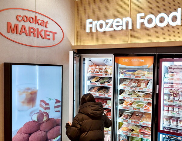 GS25합정프리미엄점에 시범 도입된 쿠캣 냉동매대에서 한 고객이 상품을 고르고 있다[사진: GS리테일]