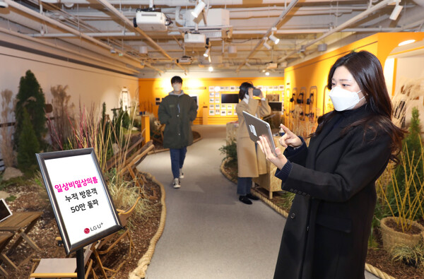 LG유플러스 모델이 ‘로컬트레인’ 전시가 진행 중인 일상비일상의틈 지하 1층에서 누적 방문객 50만 돌파를 소개하는 모습 [사진 : LG유플러스]