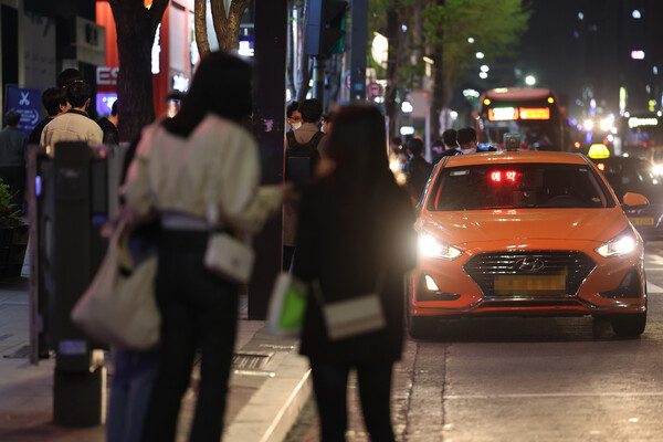 코로나19 방역을 위한 사회적 거리두기가 전면 해제된 지난달 18일 자정을 넘긴 시간 서울 강남역 인근에서 시민들이 택시를 잡기 위해 서 있다. [사진: 연합뉴스]