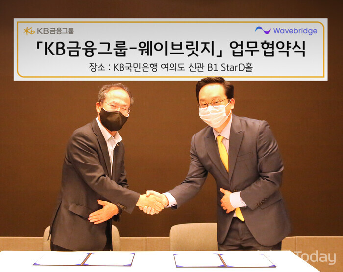 양종희 KB금융그룹 부회장(왼쪽)과 오종욱 웨이브릿지 대표가 디지털 자산 생태계 구축을 위한 업무협약 체결 후 악수를 나누고 있다. [사잔: KB금융그룹]