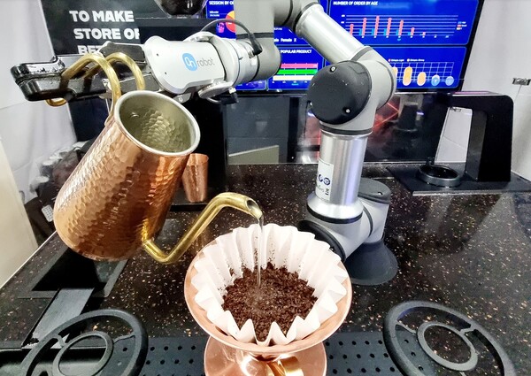 넥스트페이먼츠가 CES 2023에서 선보인 '인공지능(AI) 로봇 바리스타 카페'에서 로봇이 핸드드립 커피를 만들고 있다. 