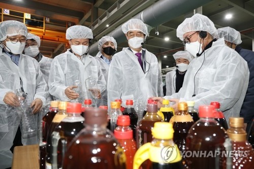 한덕수 국무총리가 설 연휴를 맞이해 수출 중소기업인 경기도 부천시 동아정밀공업을 방문해 위생모와 가운을 입고 공장을 둘러보고 있다[사진: 연합뉴스]