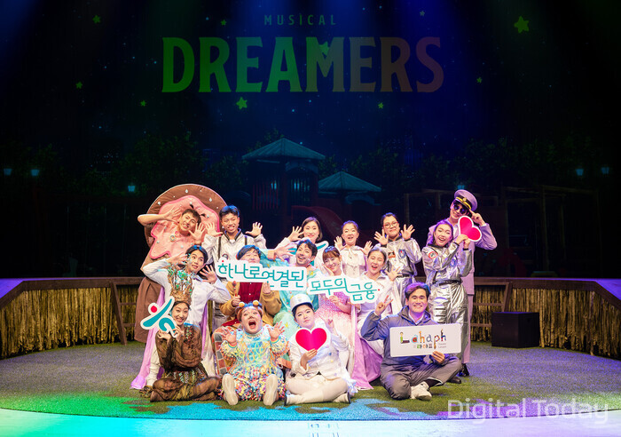 '드리머스(Dreamers)' 공연팀이 무대 위에서 밝게 웃으며 기념 촬영을 하고 있다. [사진: 하나금융그룹]