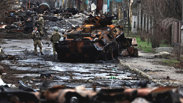 우크라이나 수도 키이우(키예프) 북부 외곽 도시인 부차에서 2일(현지시각) 우크라이나군 병사들이 파괴된 채 널브러진 러시아군 탱크와 장갑차를 배경으로 사진을 찍고 있다. [사진: AP 연합뉴스]