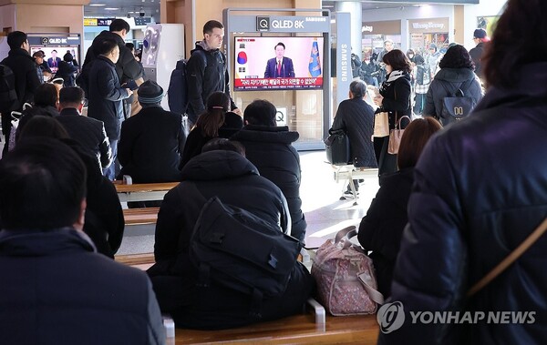 12일 오전 서울역에서 시민들이 윤석열 대통령 담화를 TV로 보고 있다. [사진: 연합뉴스]