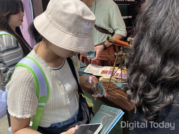 필리밀리 부스에서 전직 여정을 위한 나침반을 획득한 관람객 모습. [사진: 손슬기 기자]