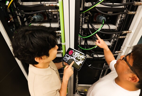 LG유플러스 직원들이 데모룸에 설치된 액체냉각장치를 살펴보고 있는 모습. [사진: LG유플러스]