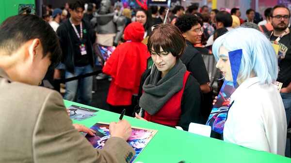 네이버웹툰 LA 애니메 엑스포에서 인기 웹툰 작가가 'SIU'가 팬들에게 사인을 해주고 있다. [사진: 웹툰엔터테인먼트]